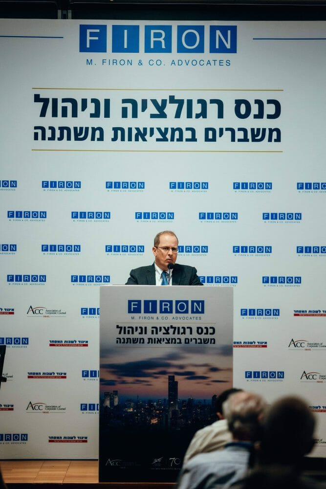 מישהו נואם בכנס רגולציה וניהול משברים במציאות משתנה