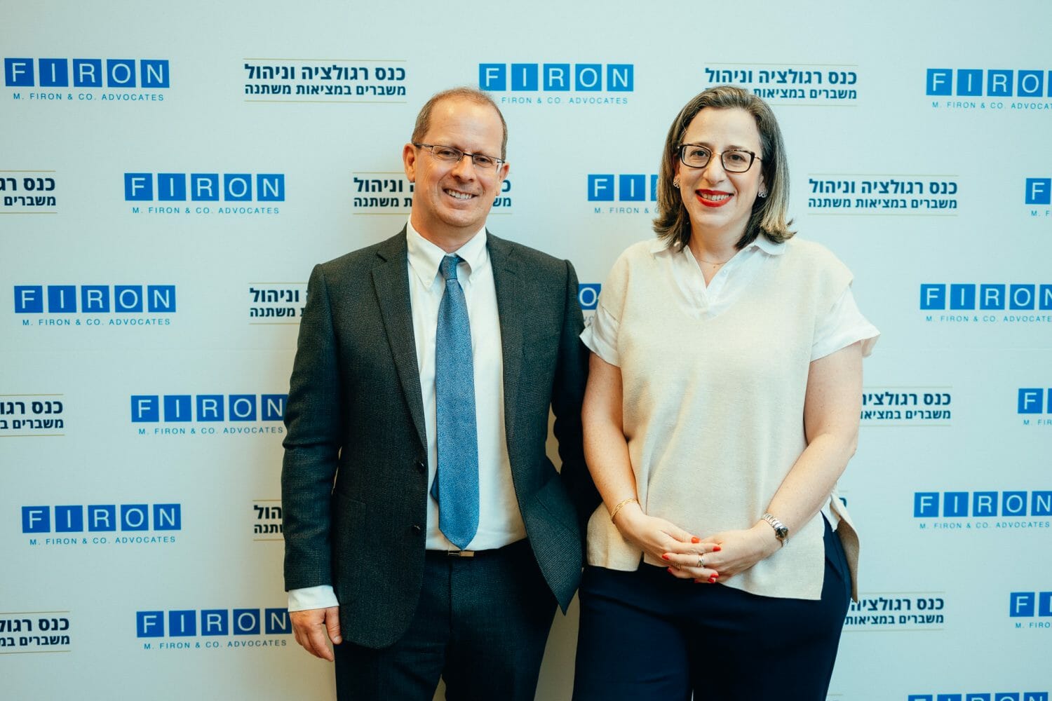אנשים מצולמים על רקע ממותג של פירון בכנס רגולציה וניהול משברים במציאות משתנה