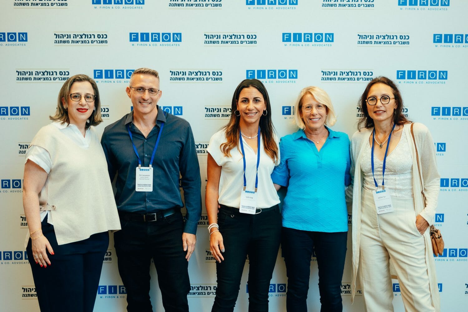 אנשים מצולמים על רקע ממותג של פירון בכנס רגולציה וניהול משברים במציאות משתנה