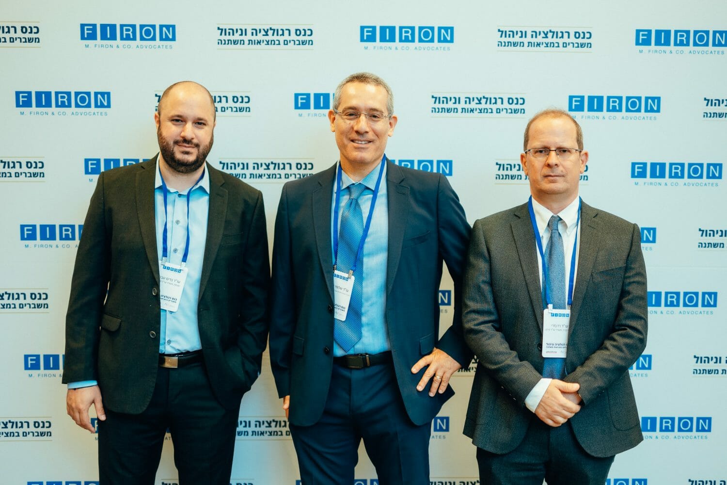 אנשים מצולמים על רקע ממותג של פירון בכנס רגולציה וניהול משברים במציאות משתנה