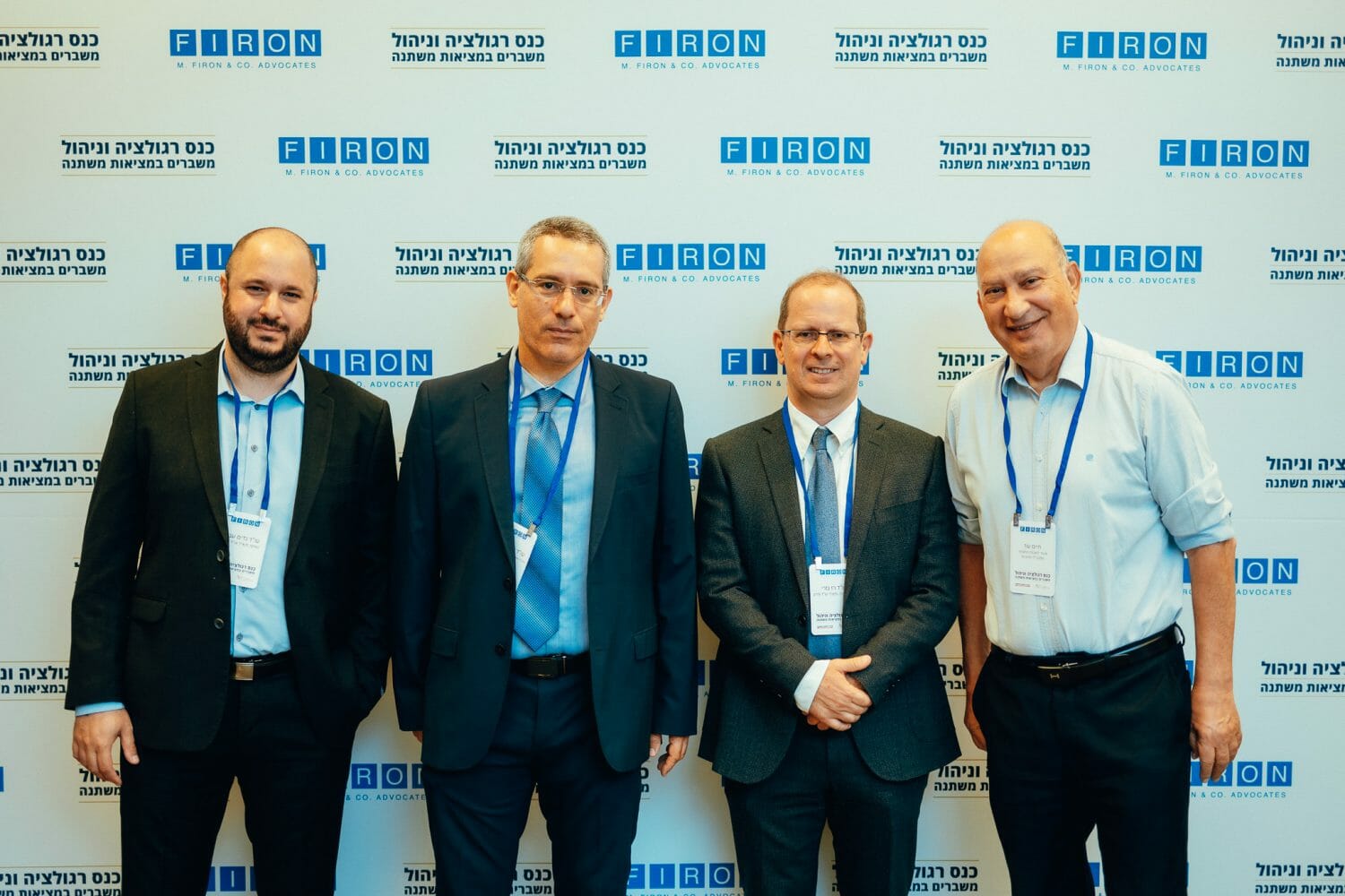 אנשים מצולמים על רקע ממותג של פירון בכנס רגולציה וניהול משברים במציאות משתנה
