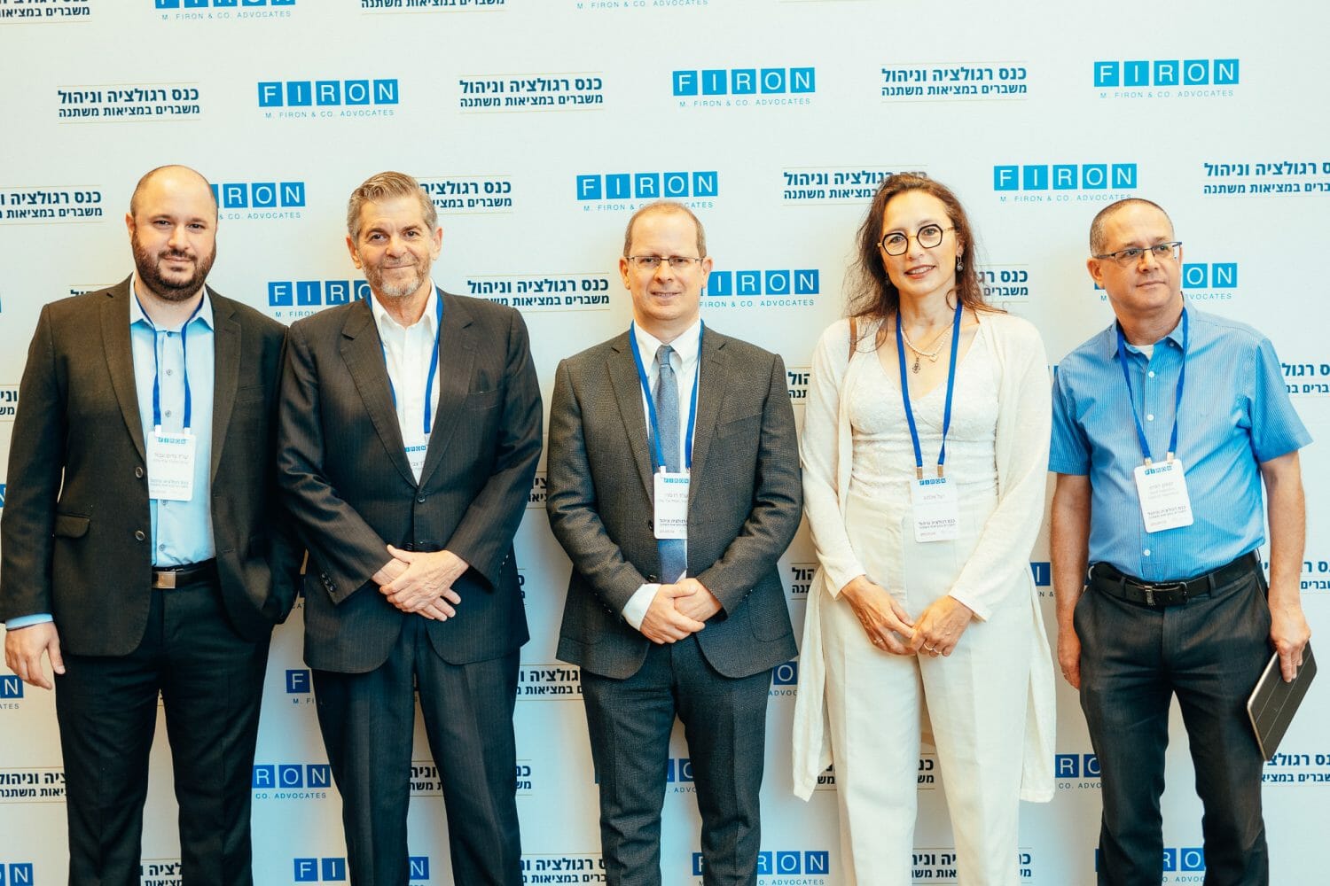 אנשים מצולמים על רקע ממותג של פירון בכנס רגולציה וניהול משברים במציאות משתנה