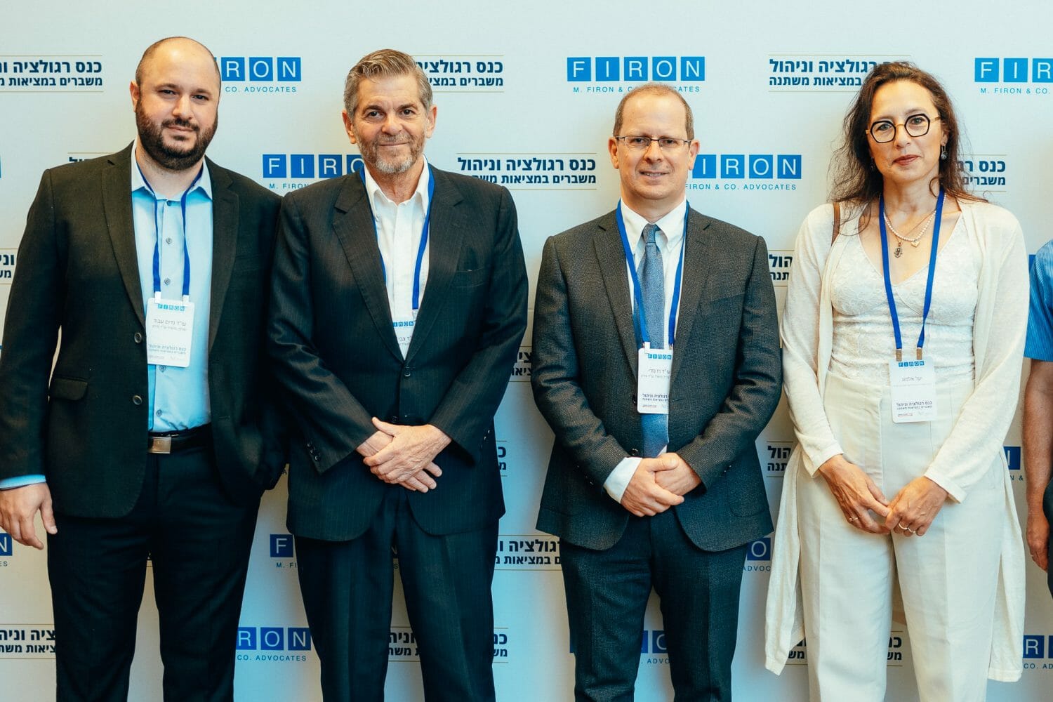 אנשים מצולמים על רקע ממותג של פירון בכנס רגולציה וניהול משברים במציאות משתנה