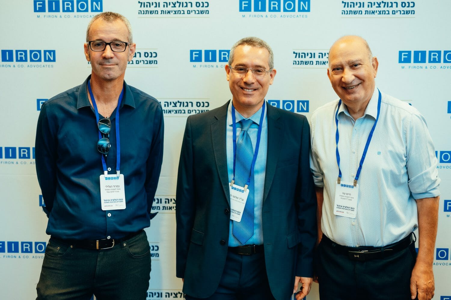 אנשים מצולמים על רקע ממותג של פירון בכנס רגולציה וניהול משברים במציאות משתנה